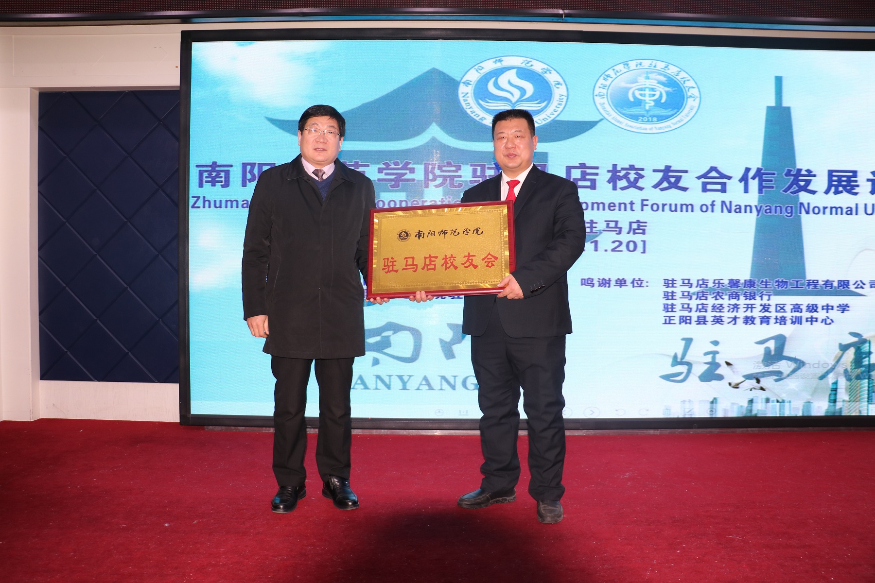 4.校长卢志文向驻马店校友会授会牌.JPG