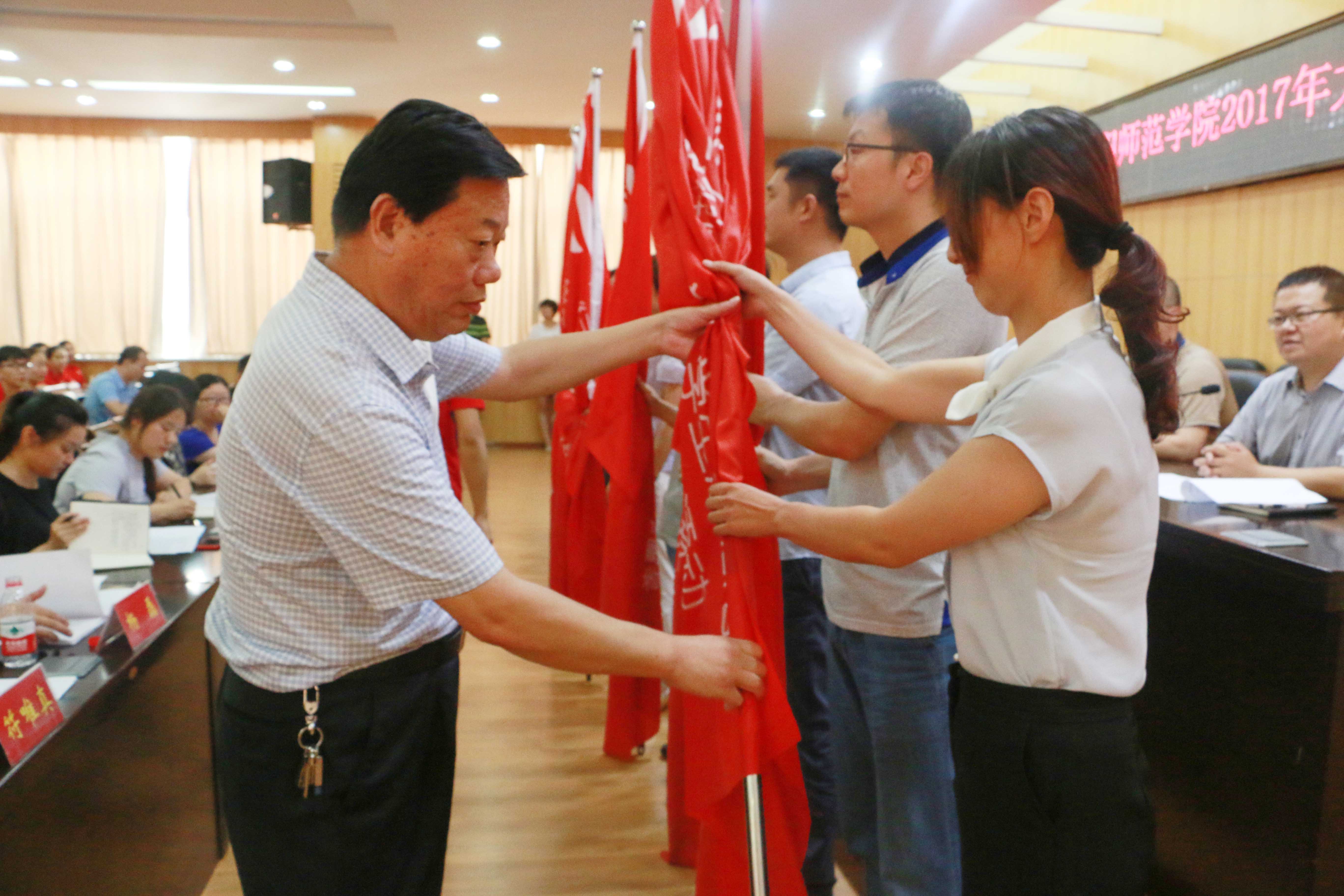 3副校长谢冰松为10个校级重点团队授旗.jpg