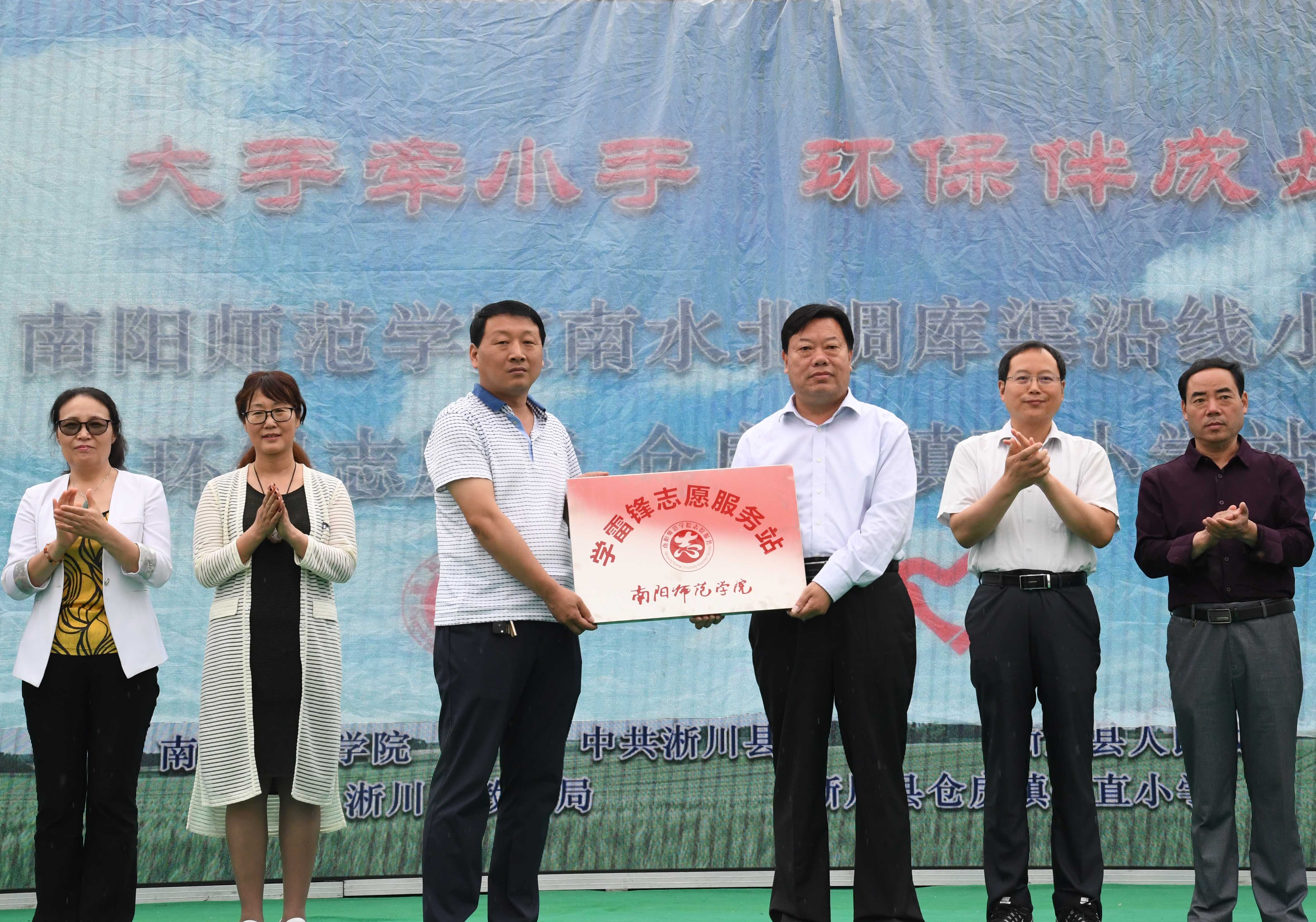 3我校党委副书记谢冰松向淅川县仓房镇镇长金钊赠送南阳师范学院学雷锋志愿服务工作站匾牌.jpg